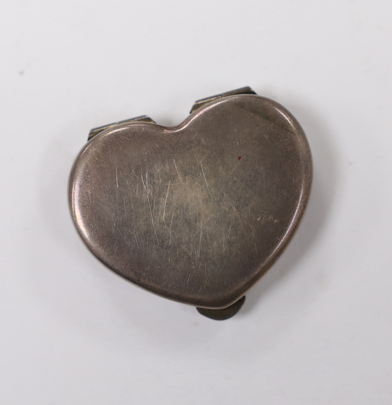 A 20th century Cartier sterling and enamel heart shaped pill box, decorated with flower heads, width 41mm.